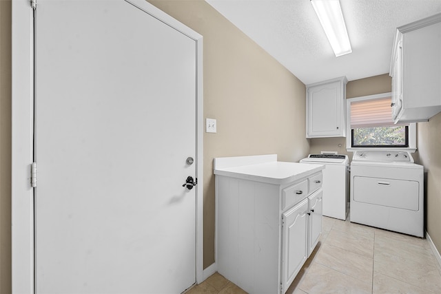 laundry room with light tile patterned flooring, separate washer and dryer, a textured ceiling, and cabinets