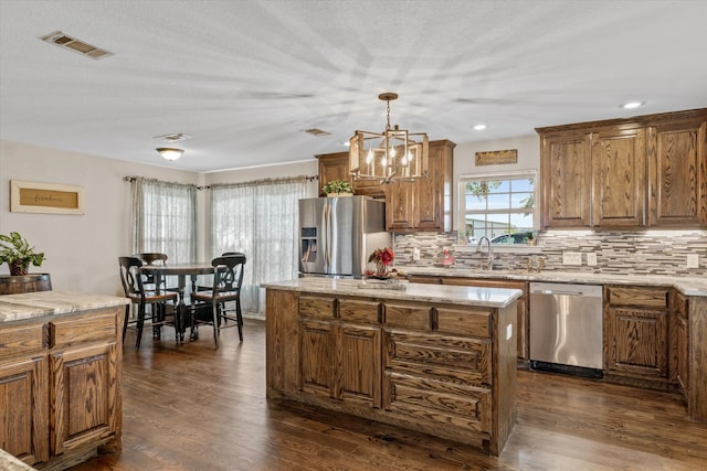 kitchen with backsplash, stainless steel appliances, dark hardwood / wood-style flooring, and hanging light fixtures