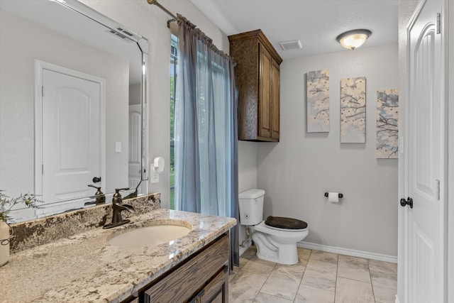 bathroom featuring a textured ceiling, toilet, vanity, and tile patterned floors