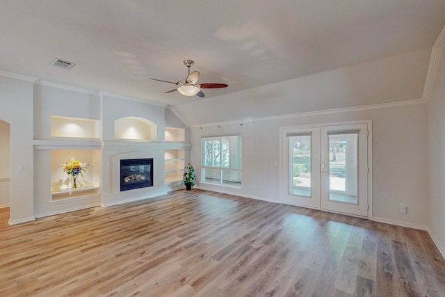 unfurnished living room with ceiling fan, built in features, ornamental molding, light wood-type flooring, and vaulted ceiling