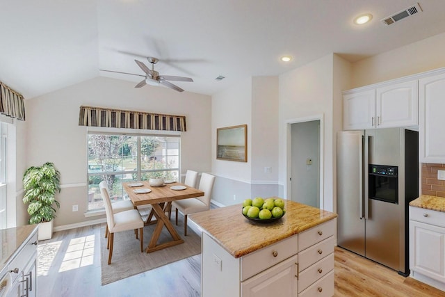 kitchen featuring light wood-type flooring, stainless steel refrigerator with ice dispenser, white cabinetry, and ceiling fan