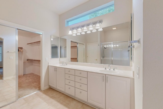 bathroom with walk in shower, vanity, and tile patterned floors