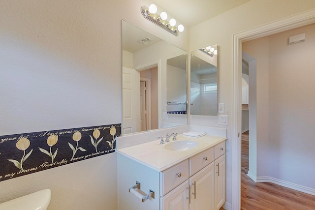 bathroom featuring vanity, hardwood / wood-style floors, and toilet