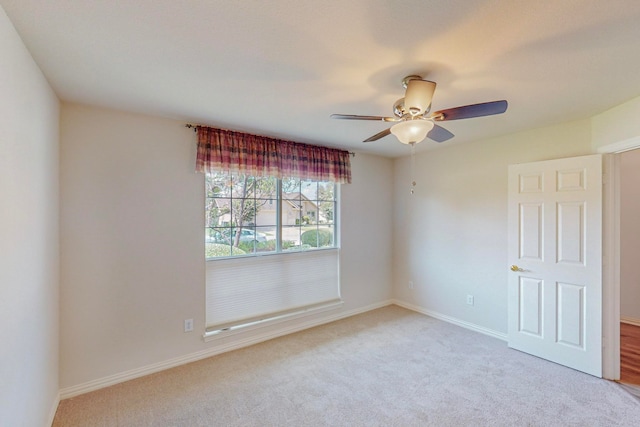 carpeted spare room with ceiling fan