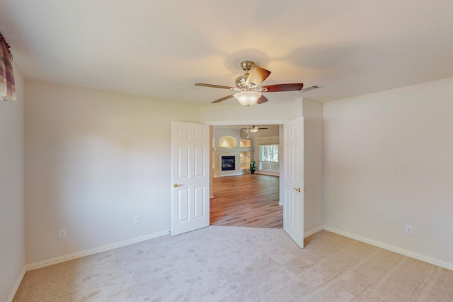 spare room featuring light carpet and ceiling fan