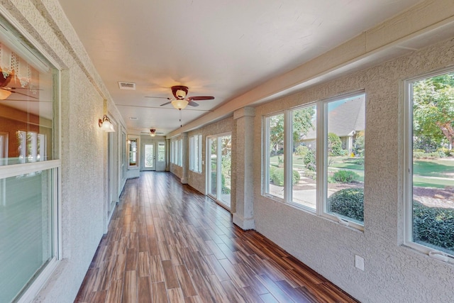 unfurnished sunroom with ceiling fan