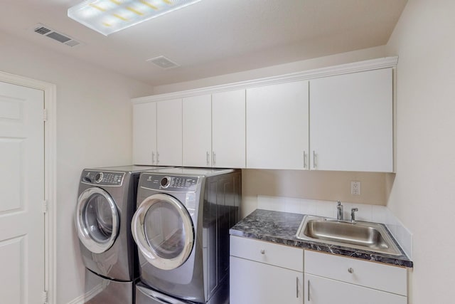 laundry area with sink, washing machine and clothes dryer, and cabinets