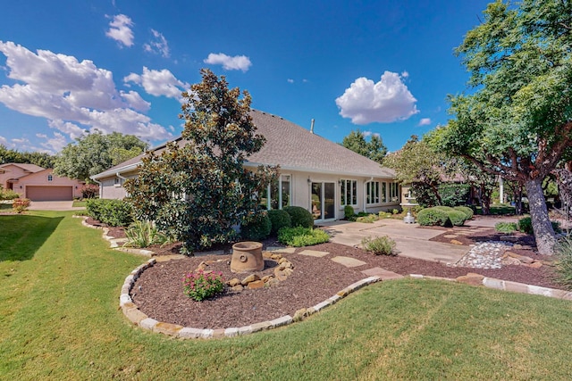 back of property featuring a lawn and a garage