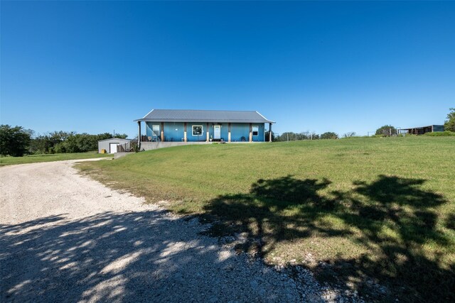 1204 County Road 122, Hico, TX 76457 - view of front facade with gravel driveway, a front lawn, a porch, metal roof, and an outdoor structure