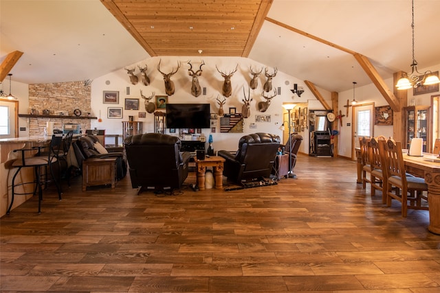 living room featuring dark wood-type flooring, lofted ceiling, a fireplace, and a chandelier