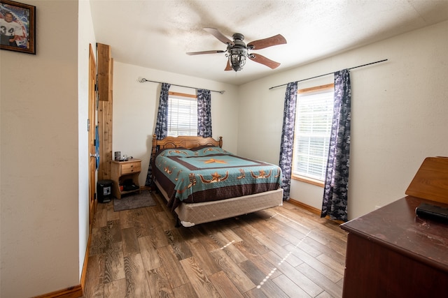 bedroom featuring a textured ceiling, ceiling fan, and wood-type flooring