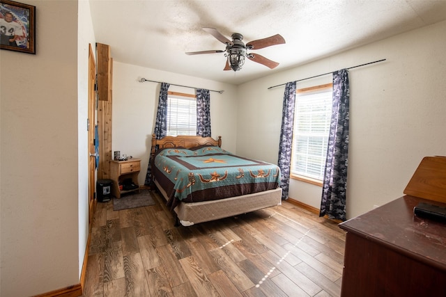 1204 County Road 122, Hico, TX 76457 - bedroom featuring multiple windows, wood finished floors, baseboards, and ceiling fan