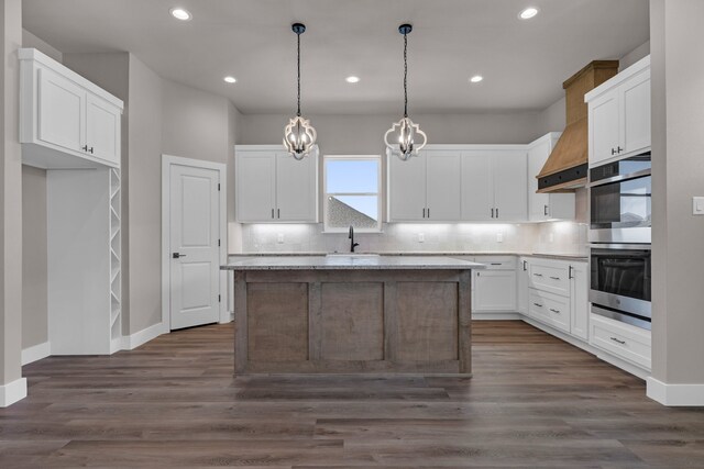 kitchen featuring dark wood-type flooring, a center island, and white cabinets