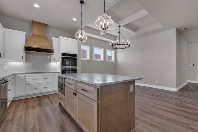 kitchen with white cabinets, premium range hood, a center island, and wood-type flooring