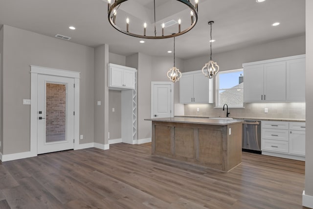 kitchen featuring white cabinets, dishwasher, dark hardwood / wood-style flooring, pendant lighting, and a kitchen island