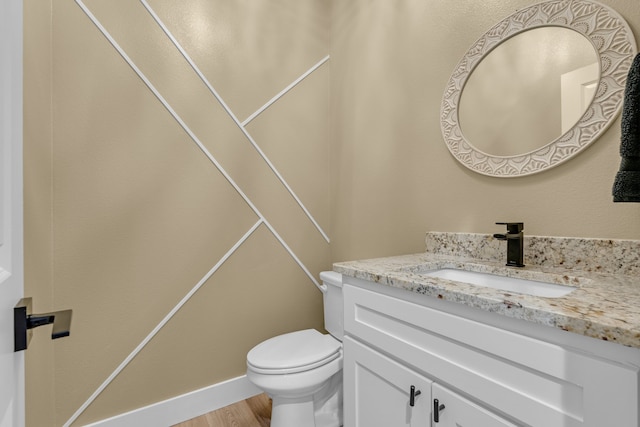 bathroom featuring vanity, toilet, and hardwood / wood-style floors