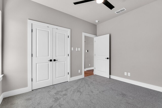 unfurnished bedroom featuring carpet flooring, ceiling fan, and a closet