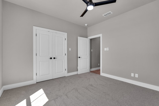 unfurnished bedroom with light colored carpet, ceiling fan, and a closet