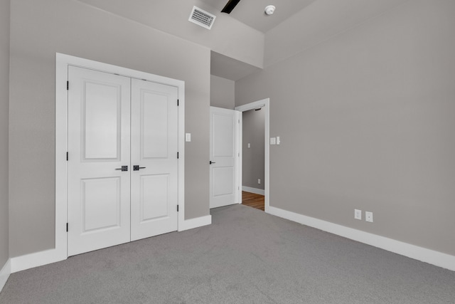 unfurnished bedroom featuring light carpet and a closet