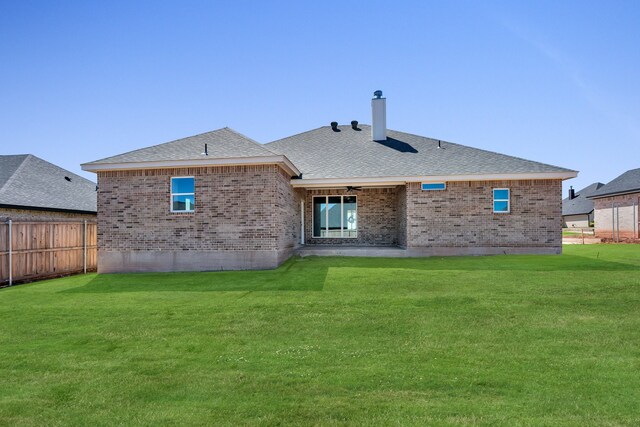 back of property with a yard and a patio area