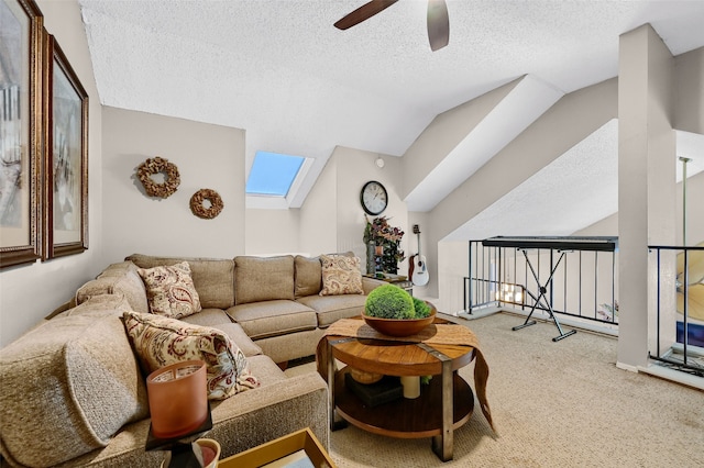 carpeted living room with ceiling fan, a textured ceiling, and vaulted ceiling with skylight