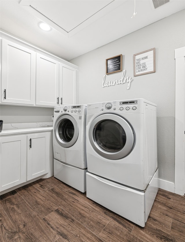 washroom featuring cabinets, washer and clothes dryer, and dark hardwood / wood-style floors