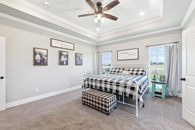 carpeted bedroom featuring multiple windows, ceiling fan, a tray ceiling, and crown molding