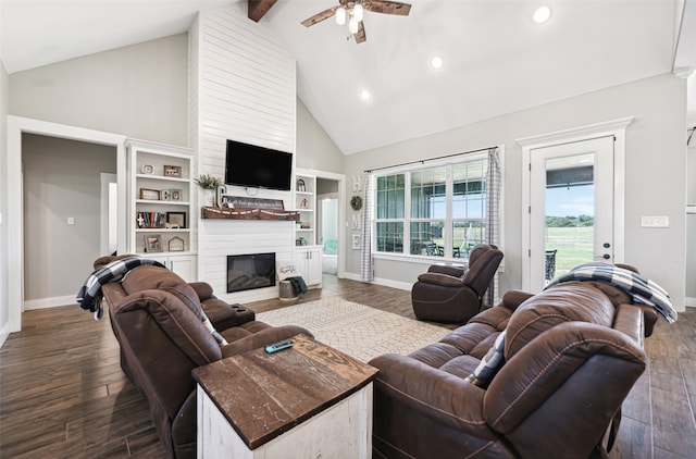 living room featuring dark wood-type flooring, a large fireplace, ceiling fan, and beam ceiling