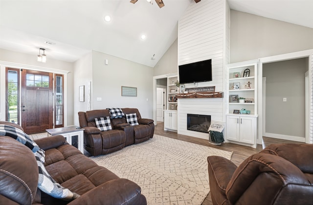 living room featuring a fireplace, high vaulted ceiling, ceiling fan, and light hardwood / wood-style floors