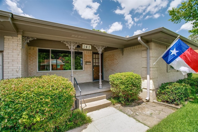 view of exterior entry featuring covered porch