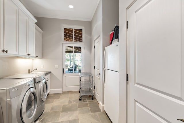 washroom with cabinets, ornamental molding, washing machine and dryer, light tile patterned floors, and sink