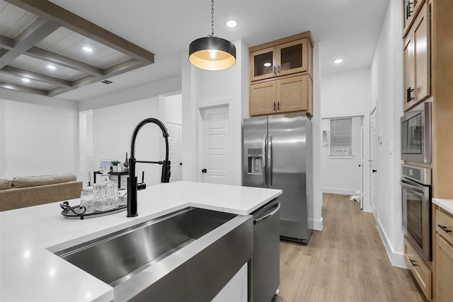 kitchen with light hardwood / wood-style floors, sink, beamed ceiling, pendant lighting, and appliances with stainless steel finishes