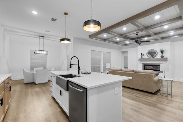 kitchen with a center island with sink, hanging light fixtures, white cabinets, light wood-type flooring, and dishwasher