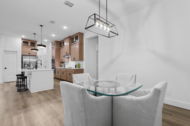 dining room with light wood-type flooring and sink