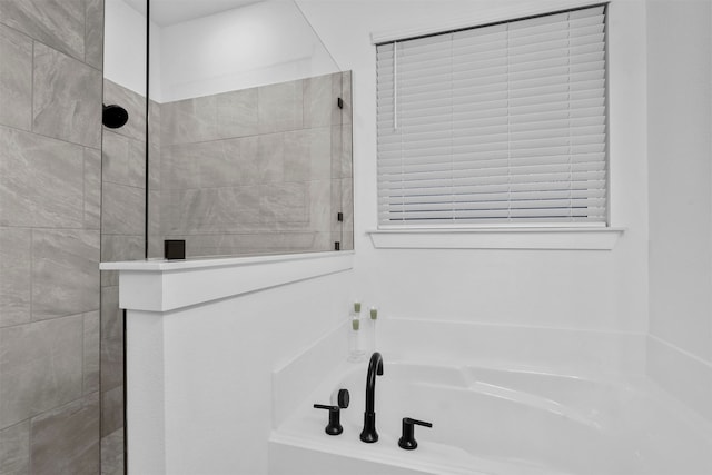 bathroom featuring shower with separate bathtub