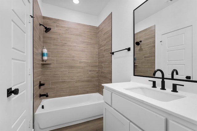 bathroom featuring wood-type flooring, vanity, and tiled shower / bath