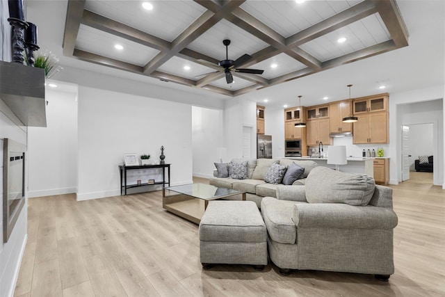 living room featuring beam ceiling, coffered ceiling, sink, light hardwood / wood-style floors, and ceiling fan