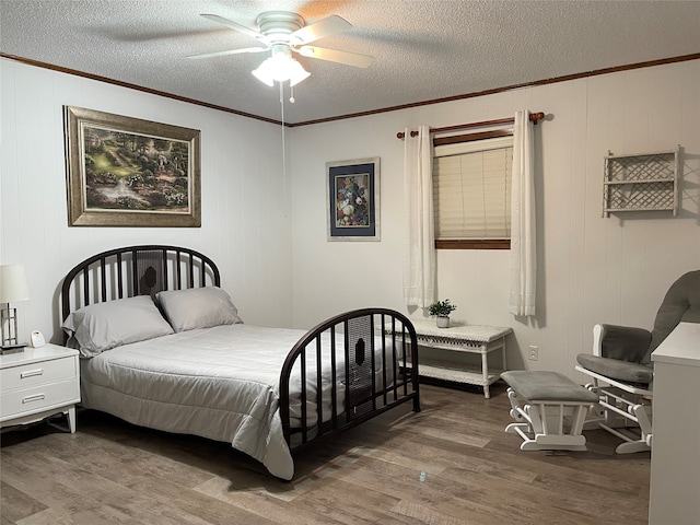 bedroom with ceiling fan, a textured ceiling, and wood-type flooring