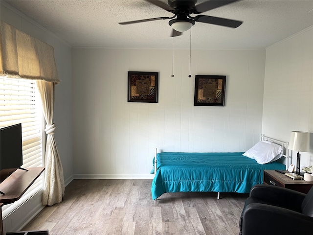 bedroom with ceiling fan, light wood-type flooring, and a textured ceiling