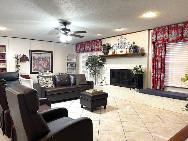 living room with ceiling fan, a brick fireplace, plenty of natural light, light tile patterned floors, and a textured ceiling