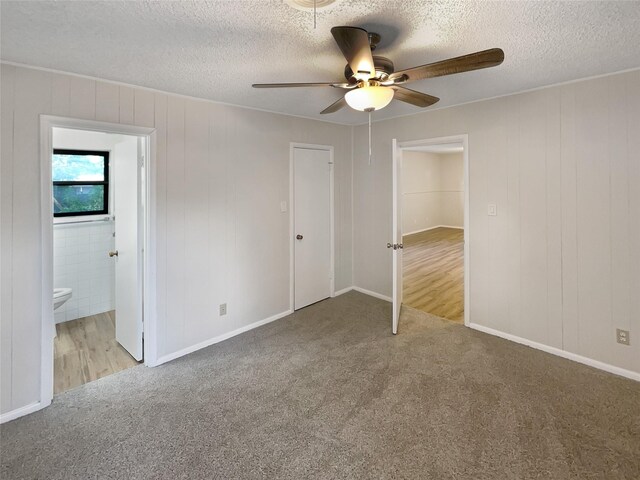 unfurnished bedroom with a textured ceiling, a closet, ceiling fan, and light carpet