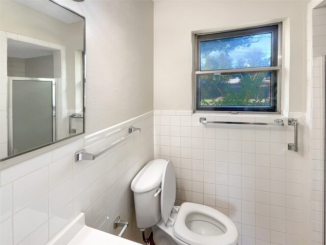 bathroom featuring toilet and tile walls