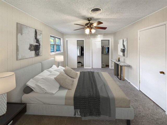 carpeted bedroom featuring ceiling fan and a textured ceiling