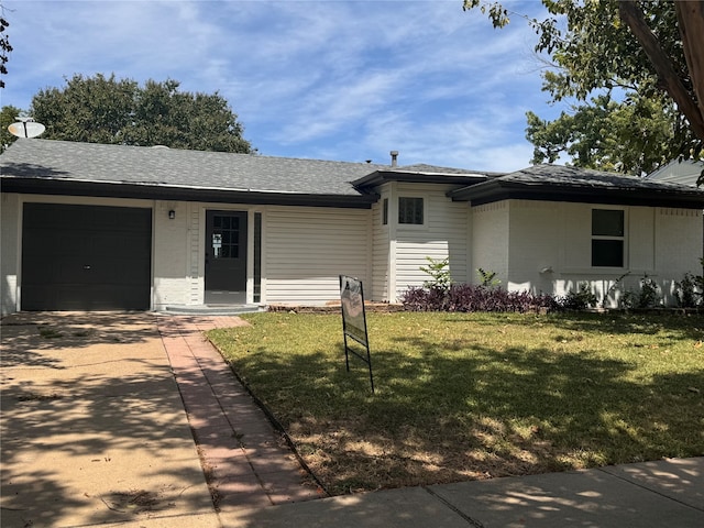 ranch-style house with a garage and a front lawn