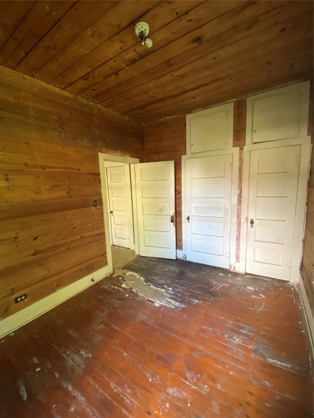 unfurnished bedroom featuring wood walls, wooden ceiling, and hardwood / wood-style floors