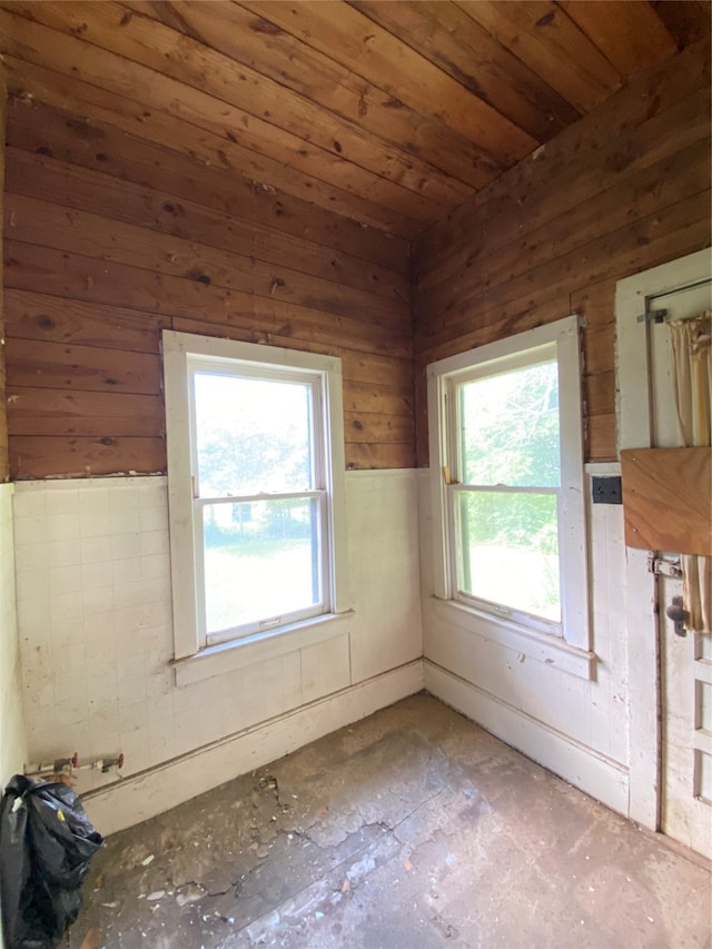 empty room featuring wood walls and wood ceiling