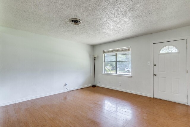 entryway featuring a textured ceiling and wood-type flooring