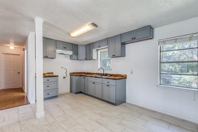 kitchen with sink, light tile patterned floors, and gray cabinets