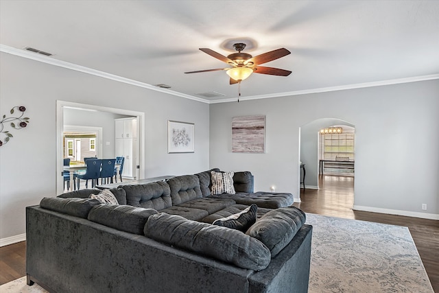 living room featuring dark hardwood / wood-style flooring, crown molding, and ceiling fan