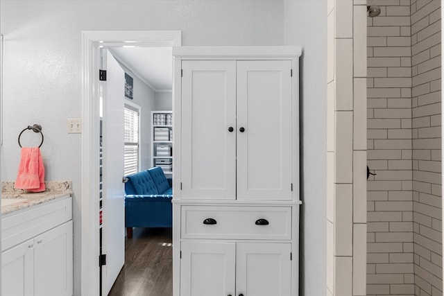 interior space featuring wood-type flooring, vanity, and ornamental molding